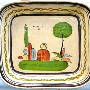 May include: A ceramic serving dish with a hand-painted design featuring a cactus, a tree, and a person wearing a hat. The dish has a brown, green, and orange border.