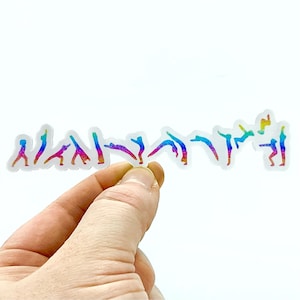 May include: A clear sticker with a row of rainbow-colored figures performing different gymnastic poses. The figures are silhouetted against a white background.