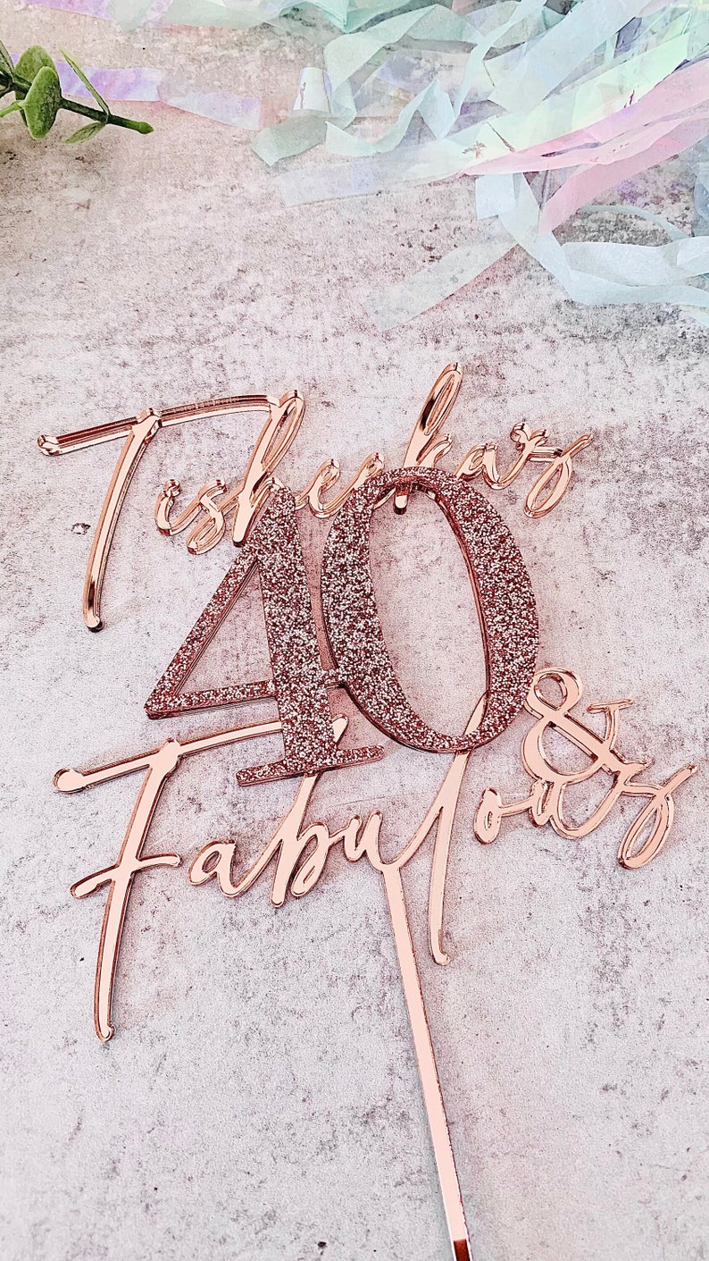May include: Rose gold glitter cake topper with the text "She's 40 & Fabulous".