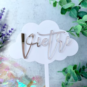 May include: White cloud cake topper with a silver glitter 'Pietri' name written in cursive.