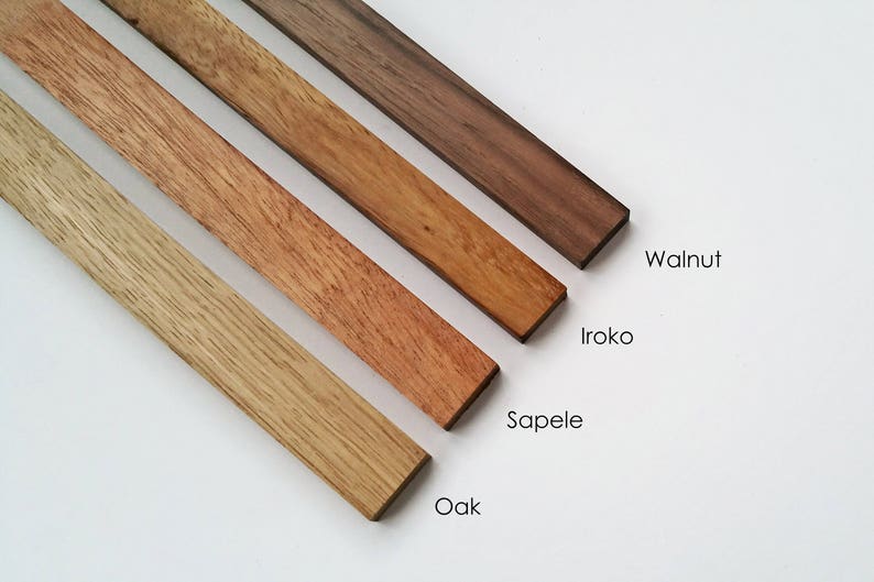 May include: Four wood samples, from left to right: Oak, Sapele, Iroko, and Walnut. The wood samples are arranged in a diagonal line, with the Oak sample at the bottom left and the Walnut sample at the top right.