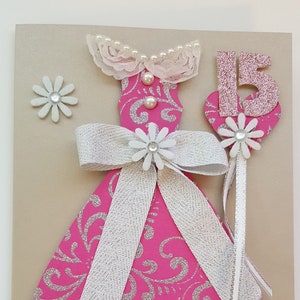 Tarjeta de felicitación de Quinceañera hecha a mano en rosa y plata, personalizada con nombre. Tarjeta de moda con vestido adornado en 3D.