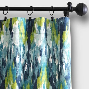 May include: A blue and green patterned curtain with a black curtain rod and finials.