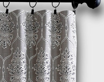 May include: Gray and white patterned curtains with a black rod and finials. The curtains have a damask design.