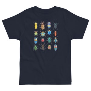May include: A navy blue t-shirt featuring a colourful pattern of various beetles. The beetles are arranged in a grid pattern and are all different colours and sizes.