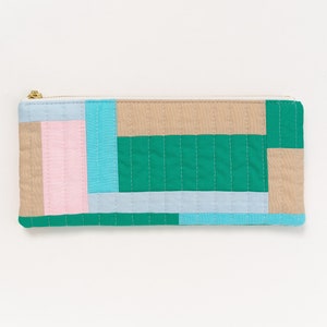 Op de afbeelding: Een gestikte rits etui met een geometrisch patroon in tinten roze, blauw, groen en beige.