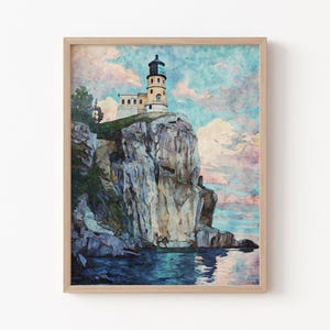 May include: A framed print of a lighthouse perched atop a rocky cliff overlooking the water. The lighthouse is painted in shades of beige and white, with a black lantern room. The sky is a mix of blue, pink, and white.