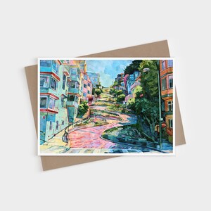 May include: A watercolor painting of a winding, steep street in San Francisco, featuring multi-colored buildings in shades of teal, pink, and orange, with lush green trees and a bright blue sky, presented as a rectangular art print on a brown envelope.