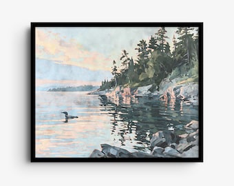 May include: A framed landscape painting depicting a loon swimming on a calm lake at sunset. The scene features a rocky shoreline with evergreen trees, reflecting soft pink and blue light across the water surface in a serene composition.