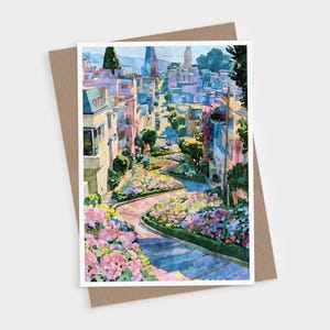 May include: A rectangular greeting card featuring a painterly illustration of a winding, steep city street lined with multi-story buildings, lush green trees, and vibrant pink and purple flower beds along the curved, paved road surface.