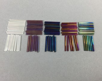 Glass bugle beads. NOS. 25x2.5mm Iris colors. Sold by lots of 125 pieces.