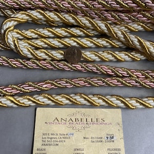 Puede incluir: Una tarjeta de visita para Anabelles Vintage Beads & Findings, ubicada en 305 E. 9th St. Suite #134, Los Ángeles, CA 90015. La tarjeta incluye el número de teléfono, el sitio web y el horario de atención de la empresa. La tarjeta también enumera los tipos de productos que se venden, incluyendo cuentas, lentejuelas, joyas, camafeos, filigranas y hallazgos.