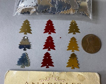 Puede incluir: Una bolsa de lentejuelas de árbol de Navidad metálicas plateadas y doradas. También hay seis lentejuelas más grandes en rojo, dorado y plateado. Las lentejuelas se muestran sobre una superficie blanca con una tarjeta de presentación para Anabelles Vintage Beads & Findings.