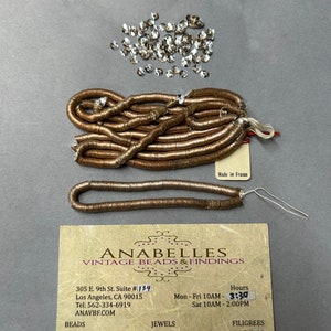 May include: A business card for Anabelles Vintage Beads & Findings, featuring a gold and brown beaded trim, a pile of clear glass beads, and the text "Made in France".