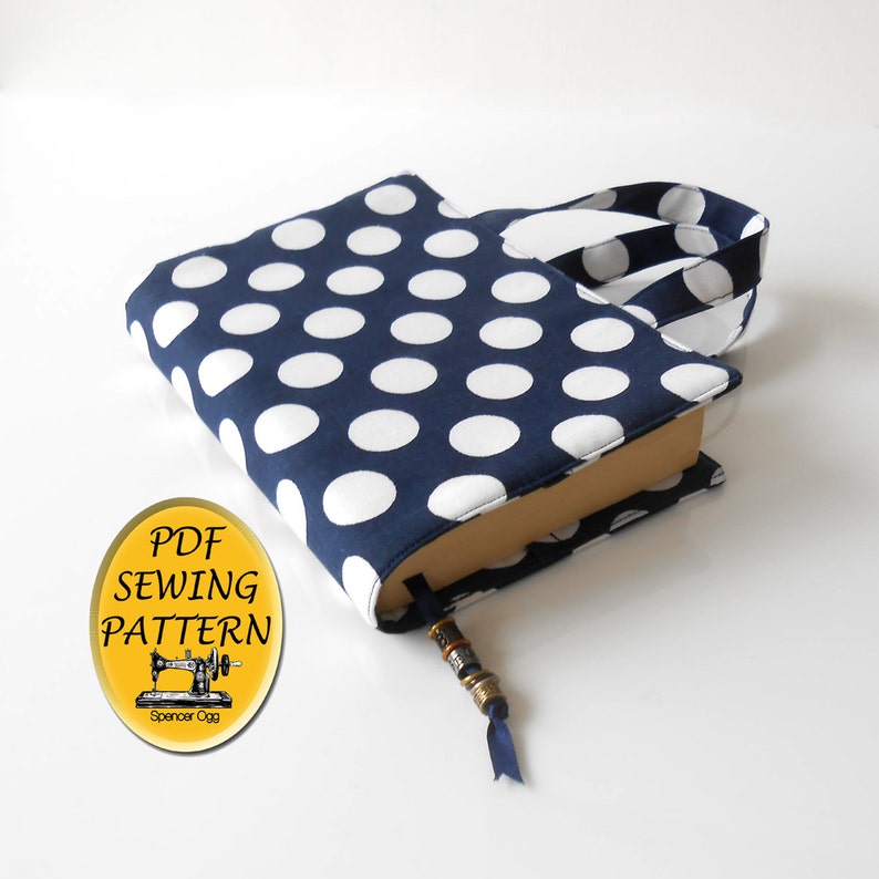 May include: A blue and white polka dot book cover with a handle and a bookmark. The cover is made of fabric and has a PDF sewing pattern.