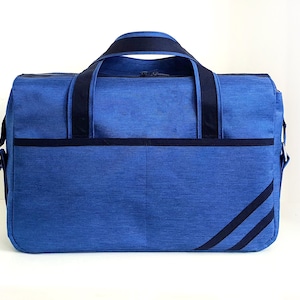 May include: A blue duffel bag with black straps and a black stripe design. The bag has a zipper closure and a shoulder strap.