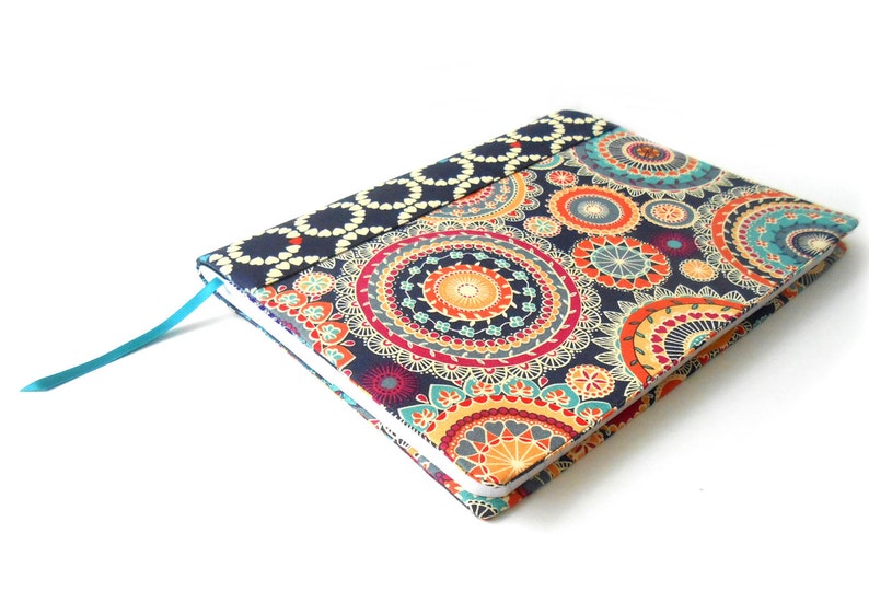 May include: A blue notebook with a colorful mandala pattern cover and a turquoise ribbon bookmark.