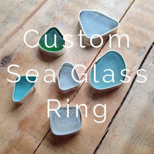 Può includere: Cinque anelli in vetro di mare diversi, ognuno con una forma e un colore unici. Gli anelli sono incastonati in argento e sono pronti per essere indossati. Anello in vetro di mare personalizzato.