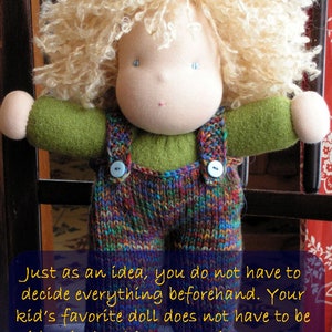 May include: A handmade doll with blonde curly hair, wearing a green shirt and colorful knitted overalls. The doll is standing in front of a wooden gate.