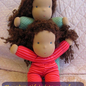 May include: Two handmade dolls with brown curly hair, one wearing a pink and white striped outfit and the other wearing a blue and white polka dot outfit. The caption reads "These beautiful sisters are from (organic) jersey cotton."