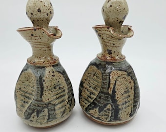 Botellas de cerámica hechas a mano para aceite y vinagre por Cariaso, firmadas en gres rústico.