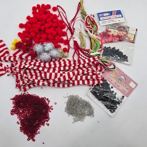 May include: A white ceramic mug with a black handle and the text "But First, Coffee" in a bold, black font. The mug is set against a blurred background, suggesting a cozy setting.