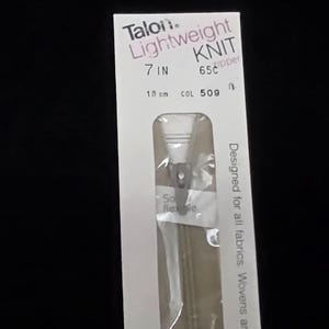 May include: A package for a Talon lightweight knit zipper. The package is white with black and pink text. The zipper is 7 inches (18 cm) long and designed for all fabrics. The color is 509.