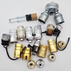 May include: A white ceramic mug with a black handle and the text "But First, Coffee" in a bold, black font. The mug is sitting on a wooden surface. The mug is approximately 4 inches tall.