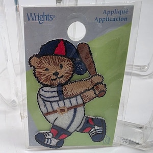 May include: Embroidered baseball-themed applique featuring a teddy bear in a baseball uniform, holding a bat. The patch is in a clear plastic package with the "Wrights" brand name and "Appliqué Application" text.