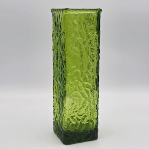 May include: A tall, square-shaped glass vase in a vibrant lime green color. The exterior surface features a distinct, heavy textured pattern that resembles rippled or hammered glass, creating a multifaceted appearance that catches the light.