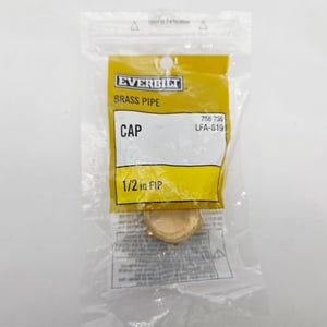May include: A brass pipe cap, labeled "EVERBILT," is packaged in a clear plastic bag. The yellow label indicates it is a 1/2 inch FIP cap. The text "CAP" is prominently displayed. The cap is made of brass.