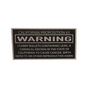 May include: A black and white warning label with the text "CALIFORNIA PROPOSITION 65 WARNING I CARRY BULLETS CONTAINING LEAD, A CHEMICAL KNOWN IN THE STATE OF CALIFORNIA TO CAUSE CANCER, BIRTH DEFECTS OR OTHER REPRODUCTIVE HARM."