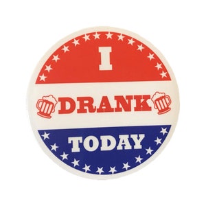 May include: A white button with a red, white, and blue design. The button says "I Drank Today" with a beer mug icon on either side of the word "Drank".