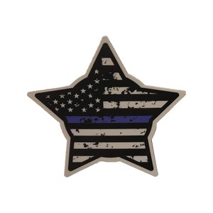 Puede incluir: Una bandera estadounidense desgastada en forma de estrella con una fina línea azul en el medio.