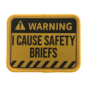 May include: Yellow and black warning sign patch with the text "WARNING I CAUSE SAFETY BRIEFS".