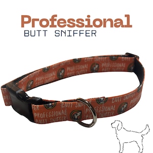 May include: An orange dog collar with the text "Professional Butt Sniffer" repeated around the collar. The collar has a black plastic buckle and a silver metal ring. A line drawing of a dog is in the lower right corner.