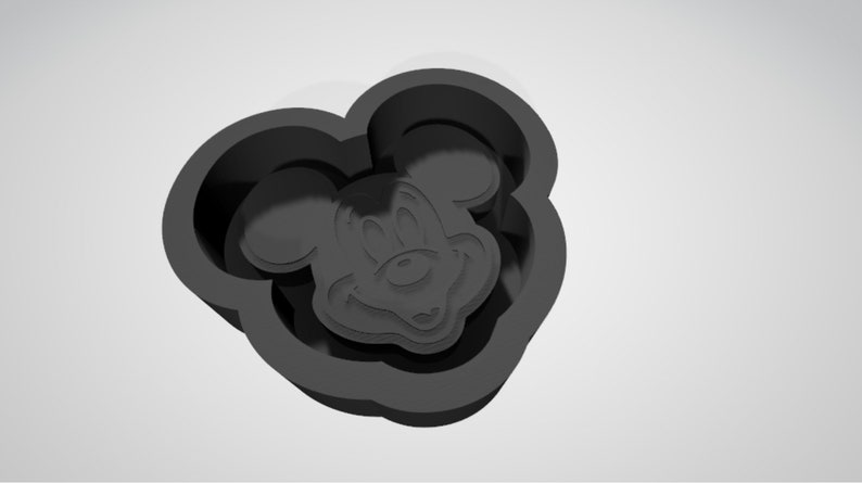 May include: Black silicone mold shaped like Mickey Mouse's head. The mold is designed to create cookies or other treats.