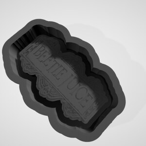 May include: A black silicone mould for baking a cake or cookie in the shape of a sign that says "Beetlejuice".