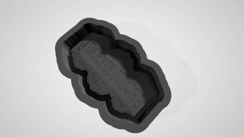 May include: A black silicone mould for baking a cake or cookie in the shape of a sign that says "Beetlejuice".
