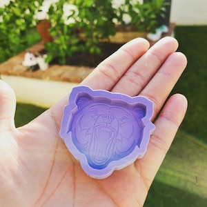 May include: Purple silicone mould shaped like a bear's head with an open mouth and detailed features.