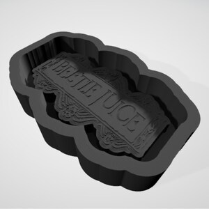 May include: Black silicone mould for making a cake or cookie in the shape of a tombstone with the words "Beetlejuice" on it.