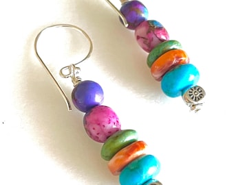 May include: A pair of dangle earrings with a silver hook and colourful beads. The beads are purple, pink, green, orange, and turquoise.