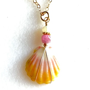 May include: A gold chain necklace with a pink and yellow seashell pendant accented with pink and white beads.