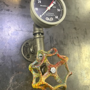 Industrieller Pfeifen-Wandhaken mit buntem Wasserhahn und Manometer