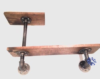 Pode incluir: Prateleira de madeira de dois níveis com suportes de tubo de metal preto. A prateleira superior é mais curta que a prateleira inferior. A prateleira inferior tem um tubo de metal preto com uma tampa de metal azul no lado direito.