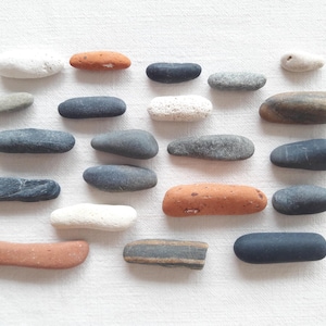 Kleine, gladde, langwerpige kiezelstenen, witte, zwarte en grijze kiezelstenen. Benodigdheden voor mineraalschilderijen, aquaria en miniatuur Zen-tuinen.