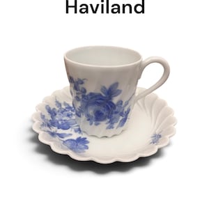 Pode incluir: Um conjunto de ch&aacute;vena e pires em porcelana branca da cole&ccedil;&atilde;o Strasbourg da Haviland. As pe&ccedil;as apresentam um padr&atilde;o floral azul, uma textura canelada em espiral na ch&aacute;vena e uma borda recortada no pires com detalhes florais azuis a condizer.