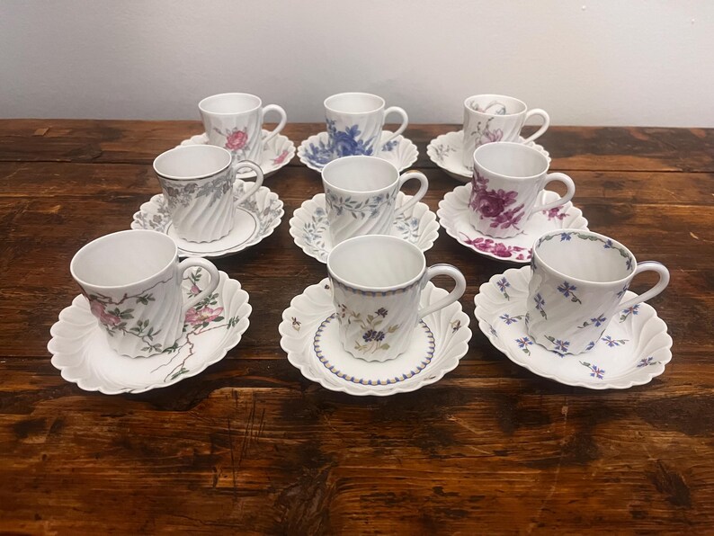 Pode incluir: Um conjunto de oito ch&aacute;venas de ch&aacute; e pires em porcelana branca, cada um com um padr&atilde;o floral &uacute;nico e uma textura nervurada em espiral. As ch&aacute;venas t&ecirc;m pegas curvas e assentam em pires a condizer com bordos recortados e desenhos bot&acirc;nicos.