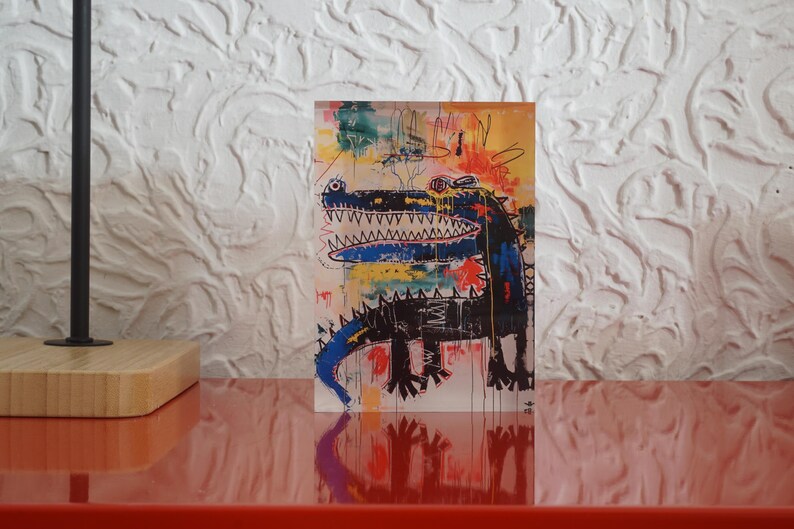 Puede incluir: Una pintura abstracta colorida de un cocodrilo con una boca azul y un cuerpo negro. El fondo es una mezcla de amarillo, naranja, rojo y azul.