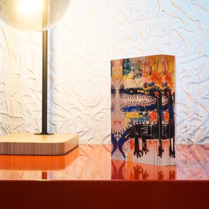 Puede incluir: Una impresi&oacute;n de arte abstracto colorida de dos cocodrilos con un fondo blanco y negro. La impresi&oacute;n est&aacute; en un bloque de acr&iacute;lico transparente.